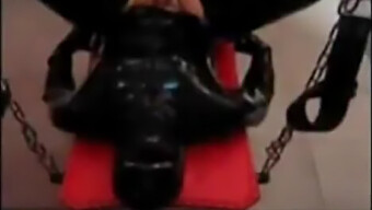 Padrona vestita di lattice domina con strapon in uno spettacolo di webcam BDSM